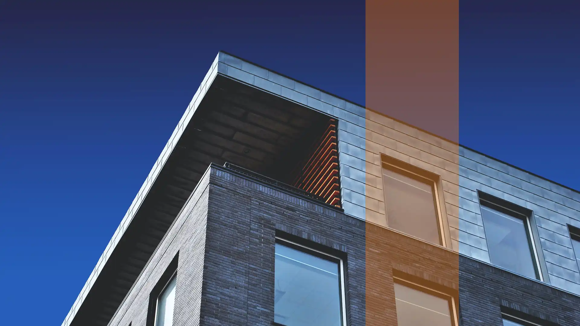 link to asset and property searches page using thumbnail of photo looking up at the corner top corner apartment of a brick building
