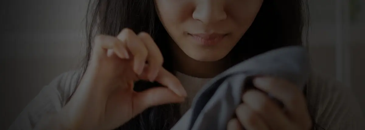 picture of a woman picking a hair off of a shirt
